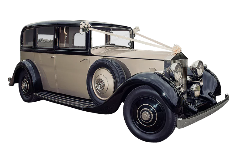 A vintage Rolls-Royce wedding car decorated with white floral ribbons, perfect for luxury wedding transportation.